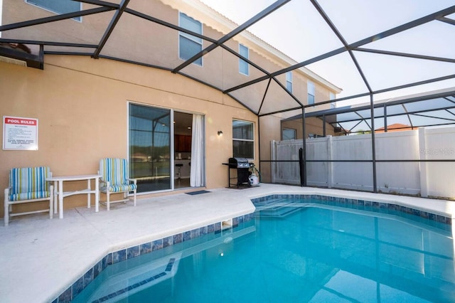 view of swimming pool with grilling area, glass enclosure, and a patio area