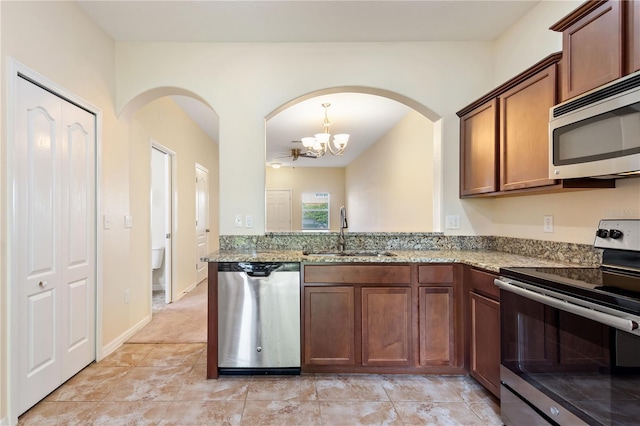 kitchen with light tile patterned flooring, sink, a chandelier, stainless steel appliances, and light stone countertops