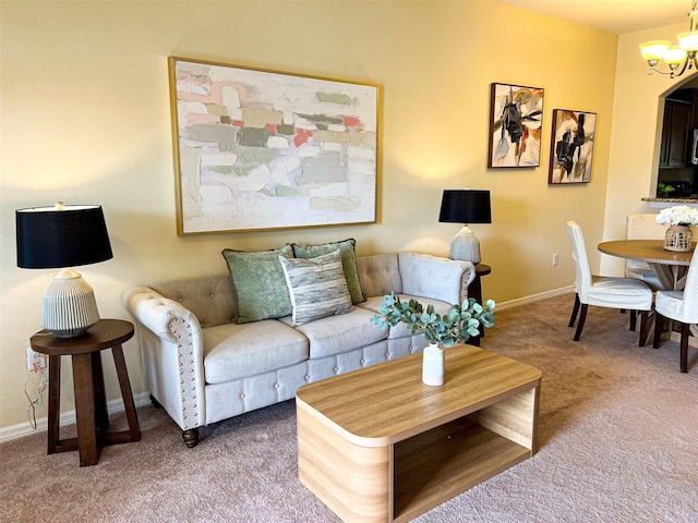 carpeted living room with a chandelier