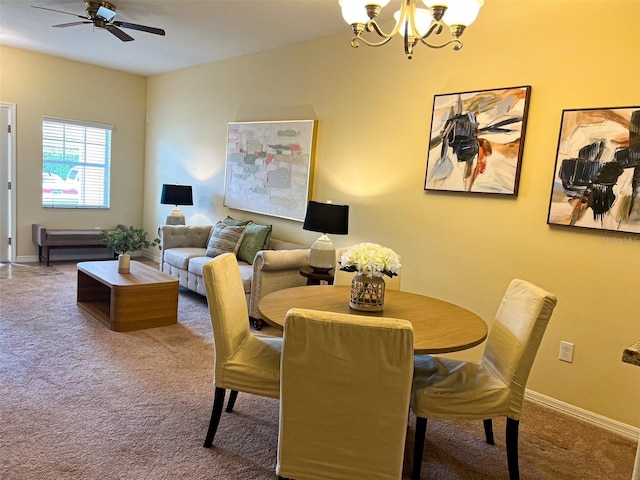 dining space featuring ceiling fan with notable chandelier and carpet floors