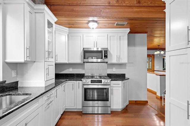 kitchen featuring stainless steel appliances, visible vents, wood ceiling, white cabinets, and hardwood / wood-style floors