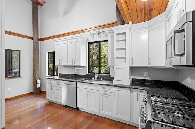 kitchen featuring appliances with stainless steel finishes, white cabinets, and a sink