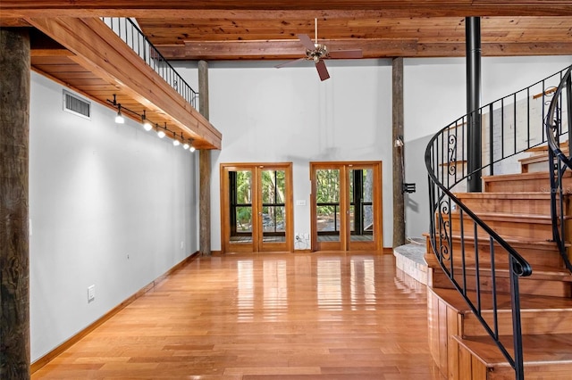 unfurnished living room featuring light wood-style floors, french doors, visible vents, and stairs