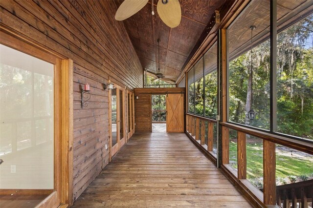 unfurnished sunroom featuring lofted ceiling, wooden ceiling, and a ceiling fan