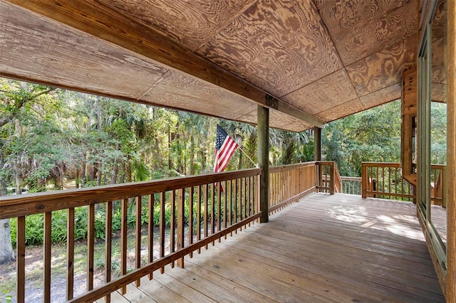 wooden terrace featuring a view of trees