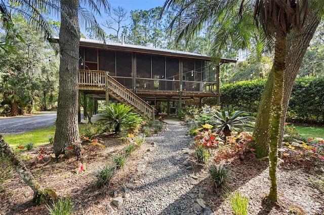 rear view of house with a sunroom and stairs