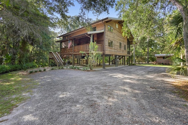 view of front of property featuring stairs and gravel driveway