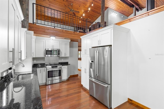 kitchen featuring high vaulted ceiling, wooden ceiling, stainless steel appliances, wood finished floors, and a sink