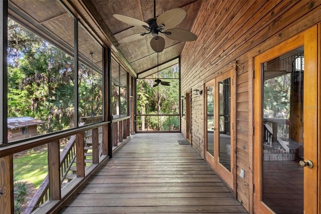 unfurnished sunroom featuring vaulted ceiling, wood ceiling, and a ceiling fan