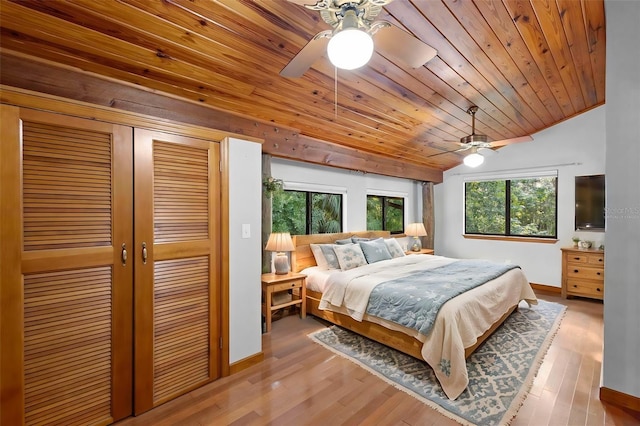bedroom with ceiling fan, wood ceiling, wood finished floors, vaulted ceiling, and a closet