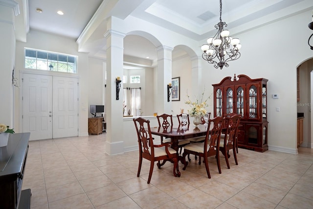 dining area featuring ornate columns, plenty of natural light, a high ceiling, and light tile patterned floors