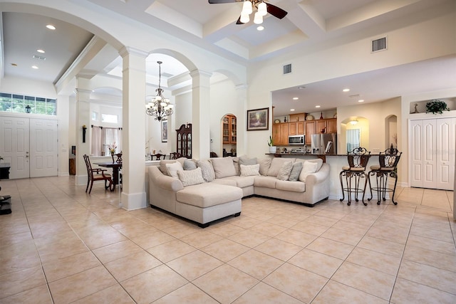 living room featuring decorative columns, a high ceiling, and light tile patterned floors