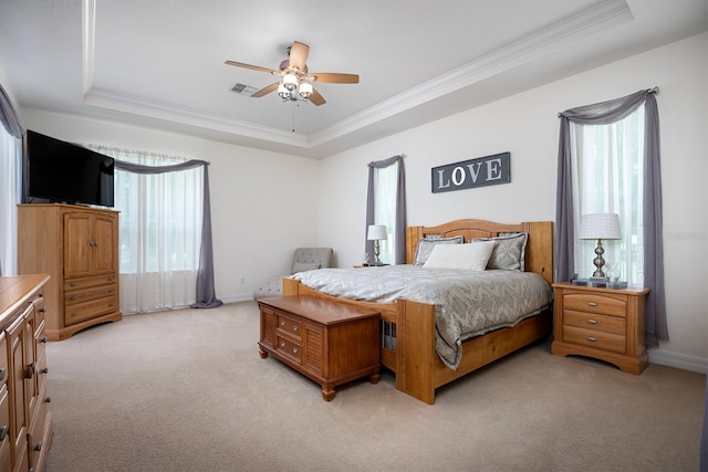 carpeted bedroom featuring multiple windows, ornamental molding, a raised ceiling, and ceiling fan