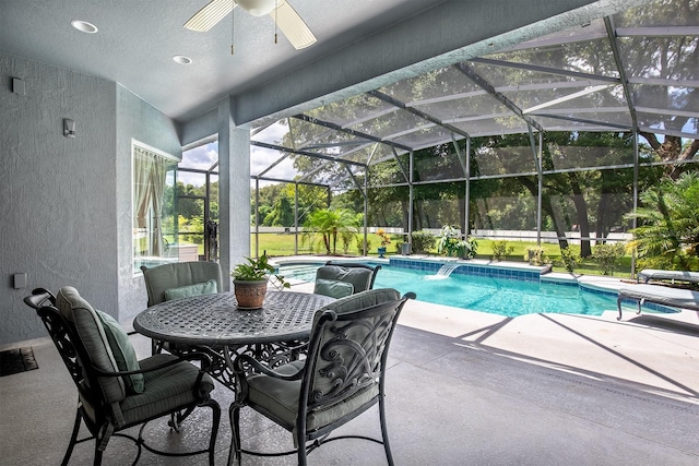 view of swimming pool with pool water feature, ceiling fan, a lanai, and a patio area