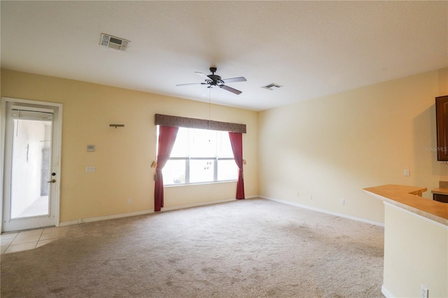 unfurnished living room featuring ceiling fan and light carpet