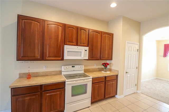 kitchen featuring light carpet and white appliances