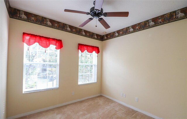 carpeted spare room with ceiling fan