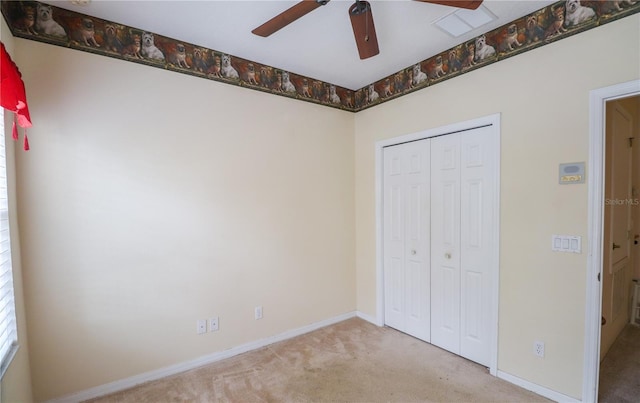 unfurnished bedroom featuring light carpet, ceiling fan, and a closet