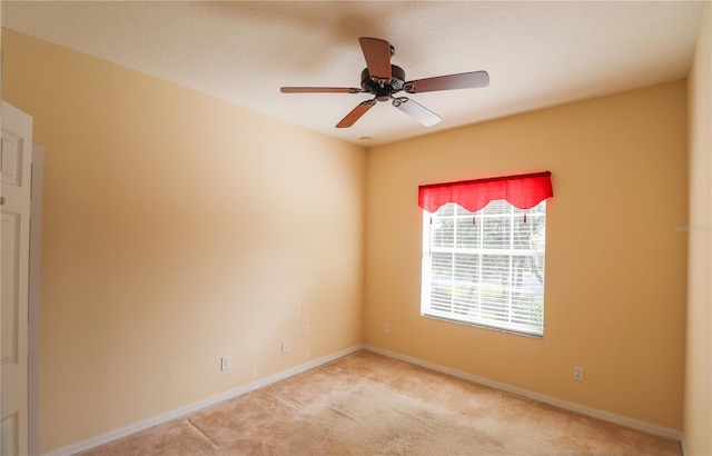 spare room with light colored carpet and ceiling fan