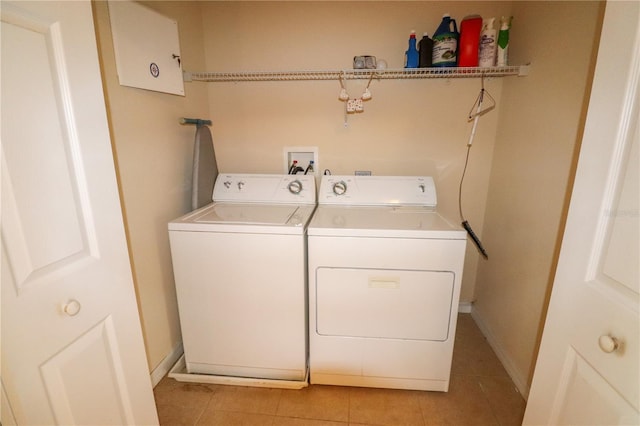 clothes washing area with light tile patterned floors and independent washer and dryer