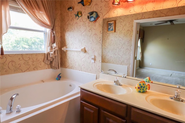 bathroom with vanity, a relaxing tiled tub, and ceiling fan