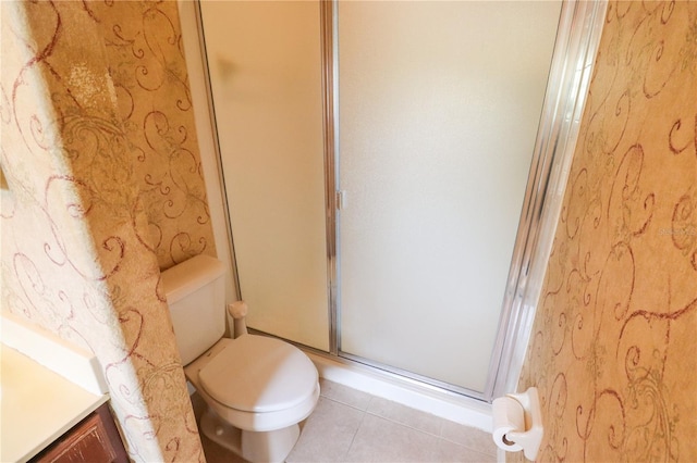 bathroom featuring toilet, an enclosed shower, and tile patterned flooring