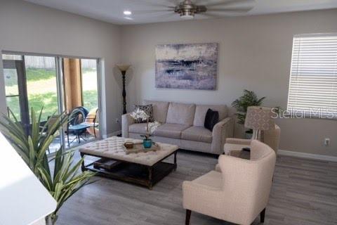 living room featuring hardwood / wood-style flooring and ceiling fan