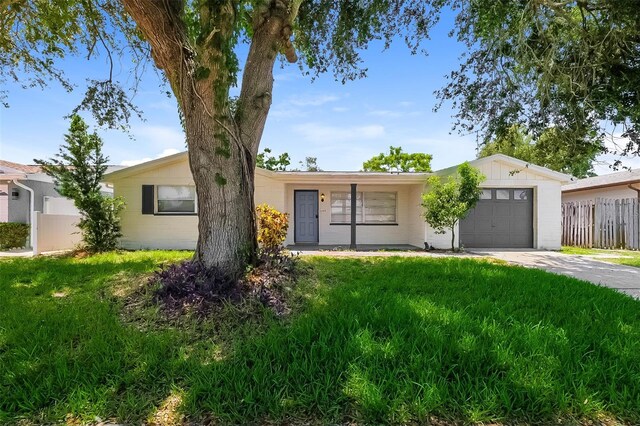 single story home featuring a garage and a front lawn