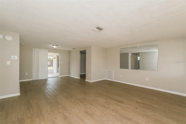 empty room featuring a textured ceiling and light wood-type flooring