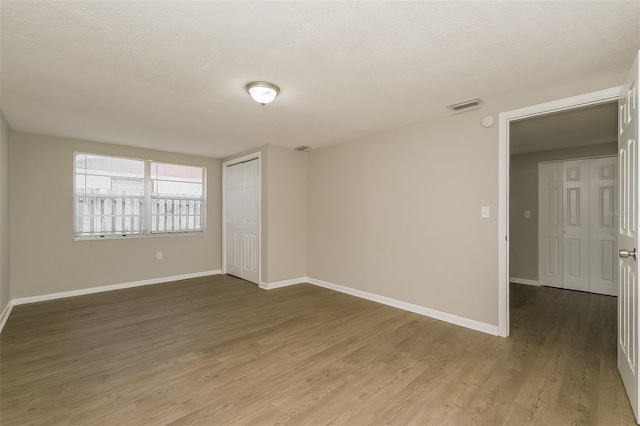 unfurnished room featuring a textured ceiling and wood-type flooring