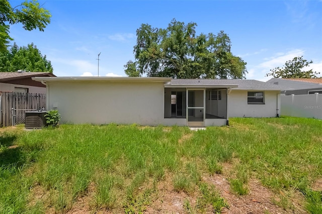 rear view of property featuring central AC and a sunroom