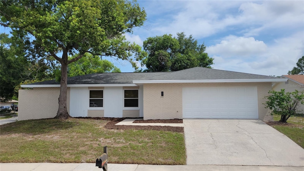 single story home with a garage and a front lawn