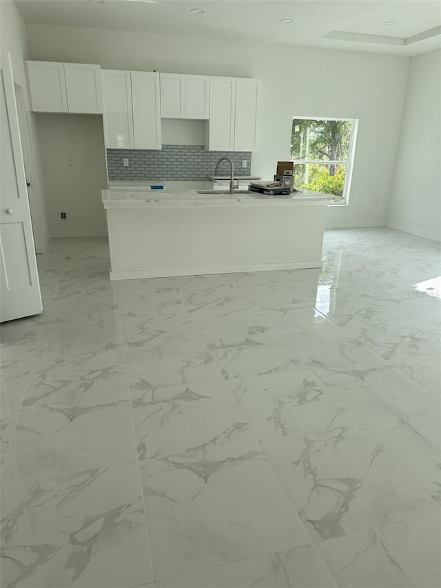 kitchen with white cabinetry, sink, and decorative backsplash