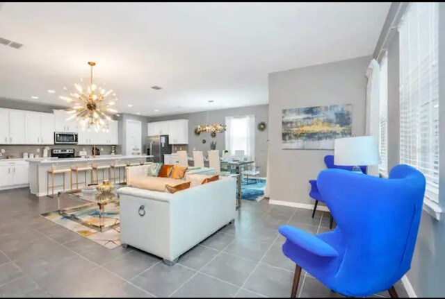 living room with light tile patterned flooring and a notable chandelier