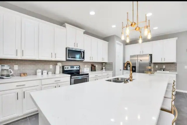 kitchen featuring a kitchen island with sink, tasteful backsplash, and stainless steel appliances