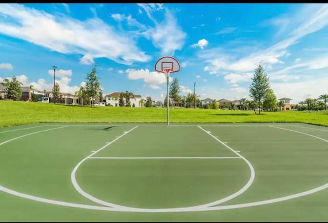 view of basketball court with a yard