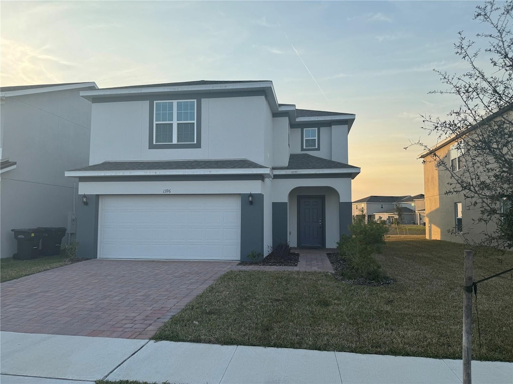 front of property with a yard and a garage