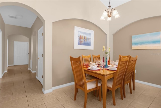 tiled dining room with a chandelier