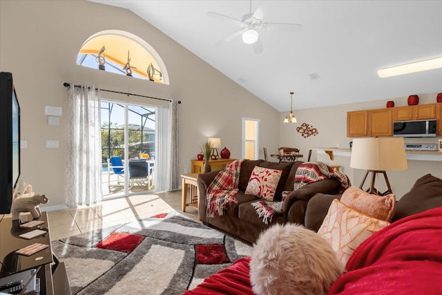 living room with ceiling fan, light tile patterned floors, and vaulted ceiling