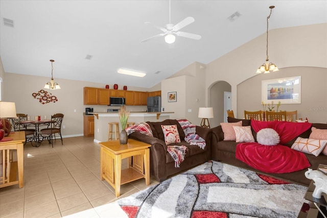 living room with ceiling fan with notable chandelier, lofted ceiling, and light tile patterned flooring