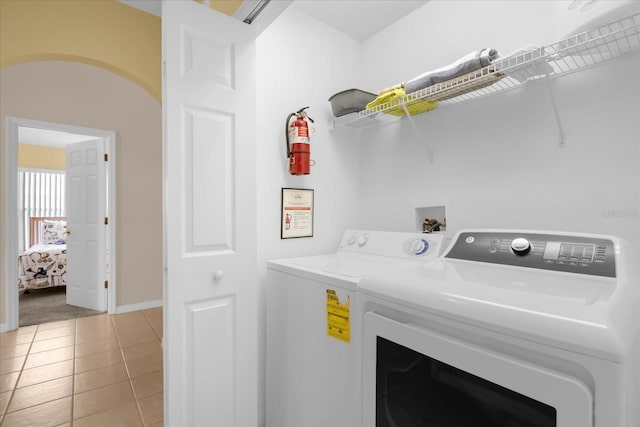 laundry area featuring light tile patterned floors and independent washer and dryer