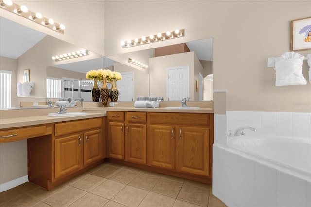 bathroom featuring tile patterned flooring, vanity, and tiled tub