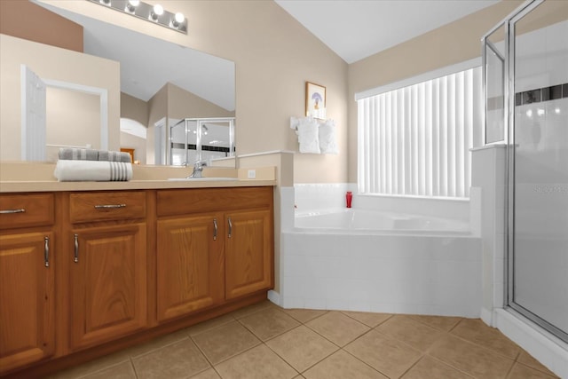 bathroom featuring tile patterned flooring, vanity, vaulted ceiling, and plus walk in shower