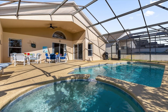 view of swimming pool featuring glass enclosure, ceiling fan, and a patio