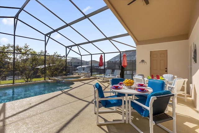 view of pool with an in ground hot tub, a patio, glass enclosure, and ceiling fan