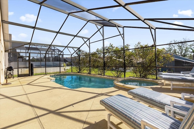 view of pool with an in ground hot tub, a patio, and glass enclosure