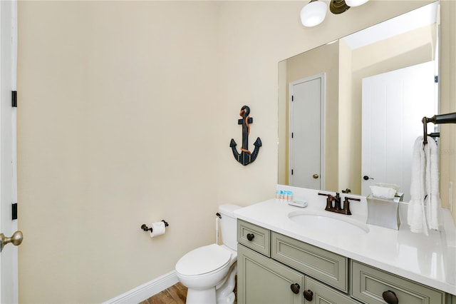 bathroom featuring hardwood / wood-style flooring, toilet, and vanity