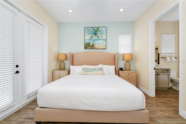 bedroom with light wood-type flooring and connected bathroom