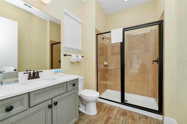 bathroom with toilet, walk in shower, and vanity