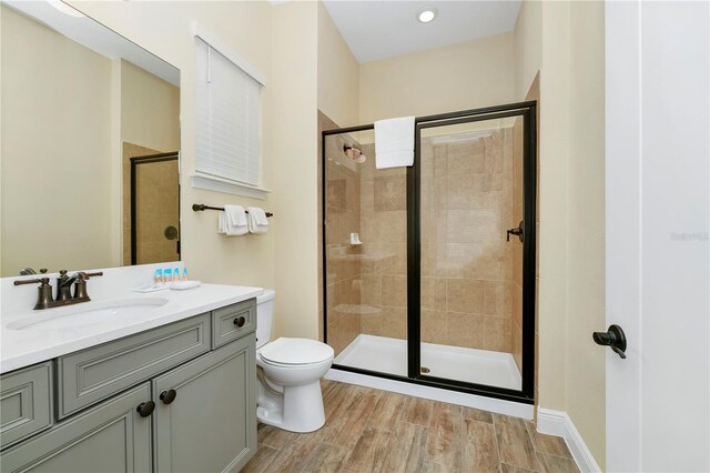 bathroom with toilet, walk in shower, and vanity